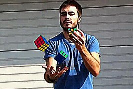 Мести рубикова коцка со една рака, додека жонглира со други две во другата