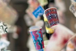 Излог со артистички чашки за кафе кои лебдат во воздухот