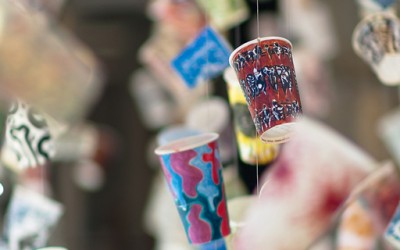 Излог со артистички чашки за кафе кои лебдат во воздухот