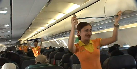 Згодни стјуардеси танцувајќи ги демонстрираат безбедносните мерки