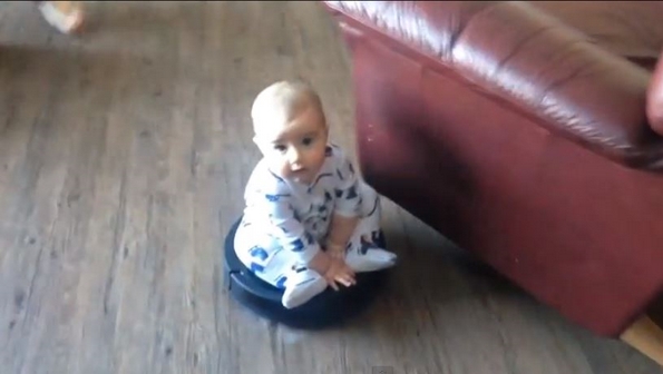 Слатко бебе си се вози на роботска правосмукалка