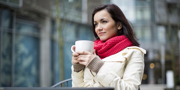 A woman sipping on a cup of coffee.