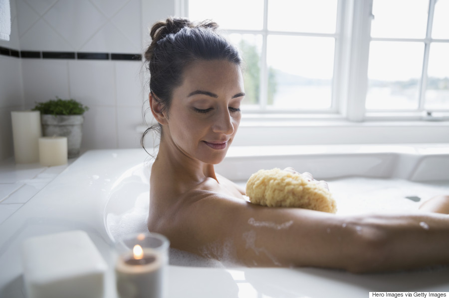 Woman using sponge in bubble bath