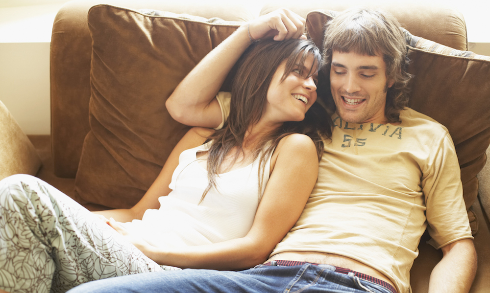Young couple sitting together on a couch and smiling