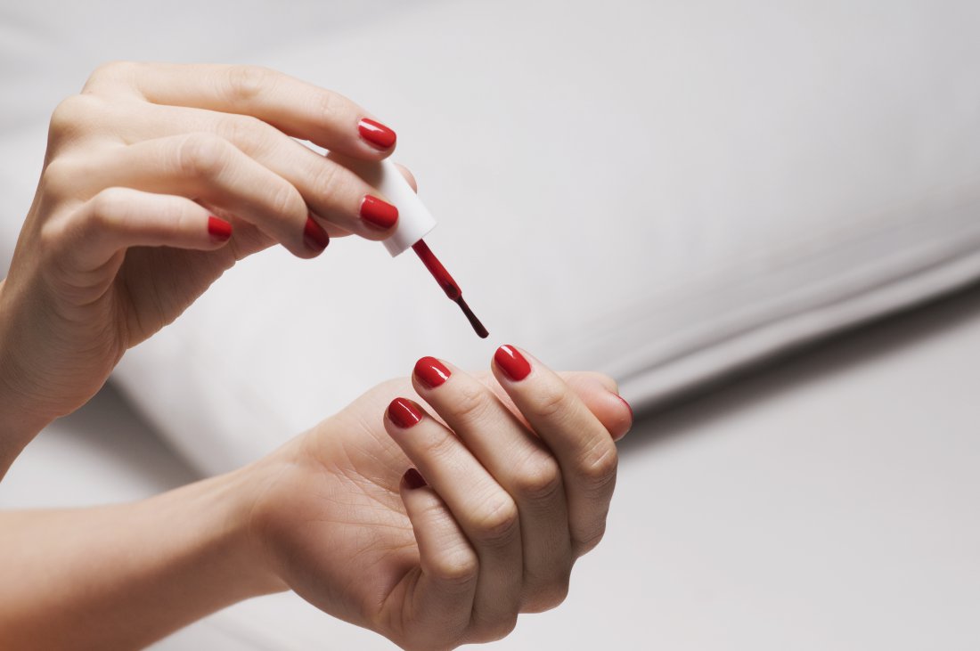 Close-up of a womans hand applying nail polish