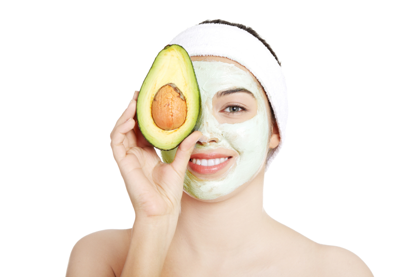 Young woman with a smile holding with avocado