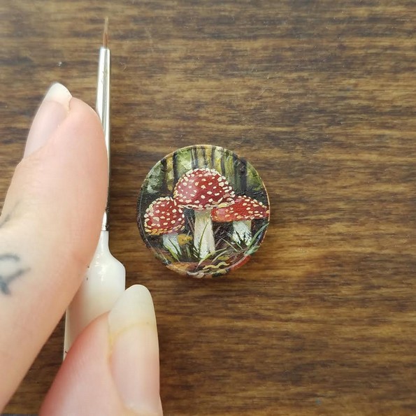 Уметница црта минијатурни слики на монети