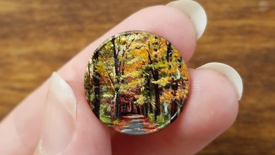 Уметница црта минијатурни слики на монети