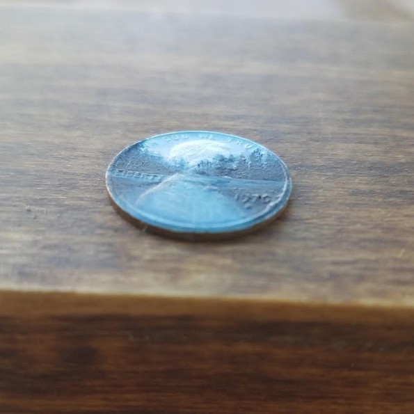 Уметница црта минијатурни слики на монети