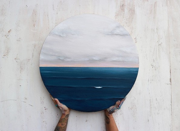 Уметница црта слики што ја слават мирната убавина на бесконечното море